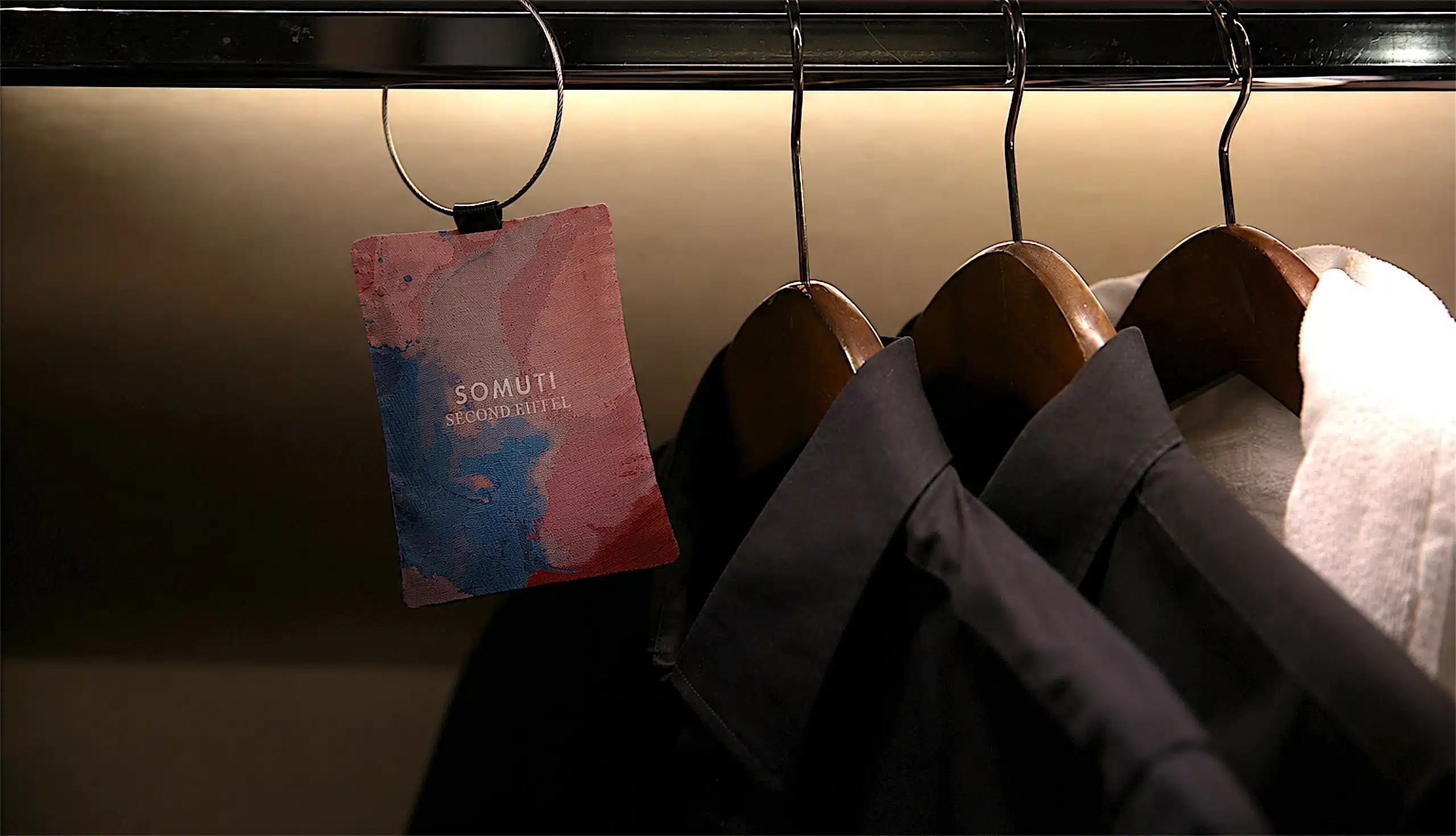 Somuti Second Eiffel scented sachet hanging in a wardrobe beside shirts